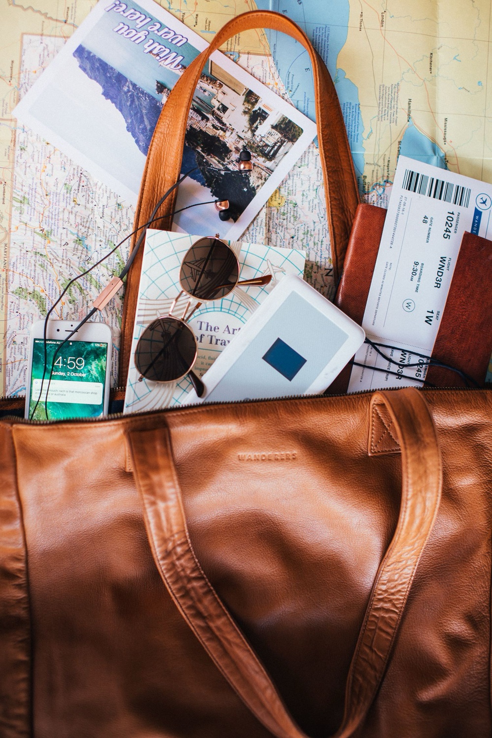 Sac de voyage avec carte, billets et lunettes, préparation d'un voyage